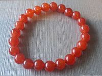 Full view of the carnelian bead stretch bracelet arranged flat