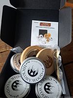 Open box showing smoker top, four tins of wood chips, spoon, brush and manual