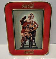 Front view showing Santa graphic, red border, gold rim and Coca-Cola logos