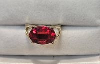 Front view showing red oval stone set in gold-tone ring
