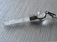 Full view of quartz point pendant lying on surface