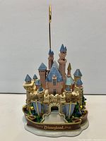 Front view of resin Disneyland castle figurine with metal photo holder rod