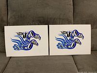 Both identical blue and black formline eagle prints on couch