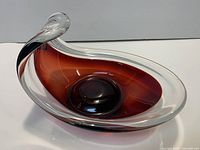 Oblique view showing twisted rim, ruby core, clear casing, interior well and overall form