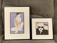 Both framed illustration prints side by side