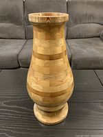 Front view of entire turned wood vase displaying segmented wood pattern and condition