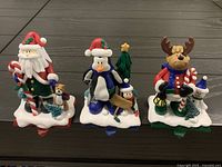 Front view of three Christmas resin figurines on snow bases