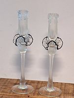 Front view of both clear glass candlesticks showing overall design