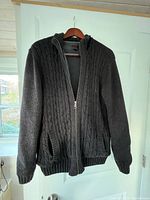 Front view of dark grey cable-knit zip cardigan on hanger