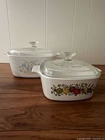 Two CorningWare casseroles with lids showing patterns