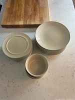 Stacked dinner plates, salad plates, and bowls on countertop