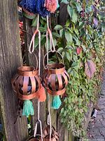 Hanging copper-tone lanterns on fence