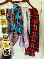Group shot of all five scarves hanging on hanger showing patterns and colours