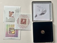 Set laid out showing three stamp sheets, coin in tin, interior lid card