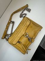 Front view of mustard leather Mini MAC showing dog-clip closure and zipper tassel