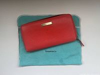 Front view of coral leather wallet on Tiffany & Co dust bag