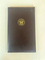 closed black presentation folder with gold seal