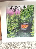 Front cover showing title Living in the Forest and forest house image