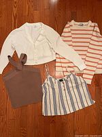 Four women’s tops laid out on hardwood floor