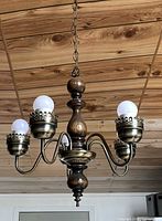 Chandelier suspended showing full profile with five bulbs and chain