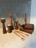Group shot showing four candlesticks, three utensils and laminated box