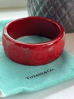 Side view of red resin bangle on Tiffany & Co. dust bag