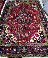 Full view of entire Persian Tabriz rug showing overall design and borders