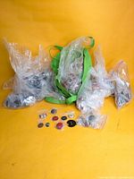 Overview showing multiple clear bags filled with buttons and several sample buttons laid out