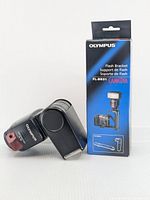 Olympus FL-40 flash next to FL-BK01 bracket box
