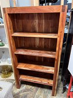 Front view of wooden bookshelf showing four shelves and dovetail joints