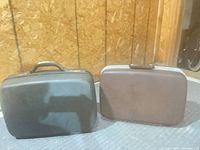 Front view of both black and brown Samsonite suitcases side by side