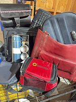 Group shot showing rolling laptop bag, red leather laptop bag, keyboard, thermos set, lunch cooler, toiletry bag