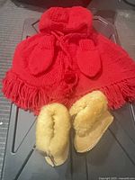 Red hooded parka with mittens and tan shearling moccasins