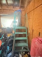 Full view of green steel rolling ladder in storage