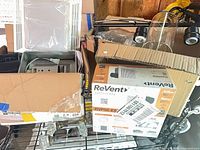 Overall lot showing boxed ReVent fan, additional boxed fan, antique glass door knobs, black track light with glass shades