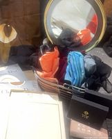 Basket with rolled scarves, lighted mirror, hosiery boxes, gift box