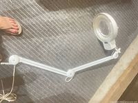 Entire magnifier lamp arm laid flat on floor showing overall structure