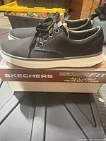 Side view of sneakers on box showing canvas upper and outsole