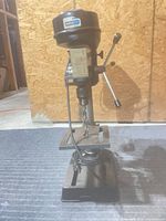 Full view of Nikota benchtop drill press showing base, column, table, motor housing and power cord