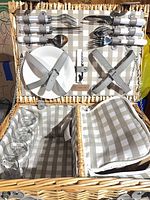 Open picnic basket showing plates, cutlery, corkscrew, cooler compartment