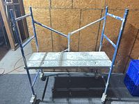 front view of scaffold showing frame, platform and casters