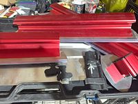 Assorted red skimming blades stacked in black carry case