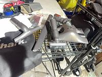 All four Shark vacuum attachments and storage bag on wire shelf