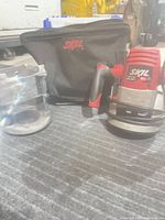 Router motor in plunge base next to bag