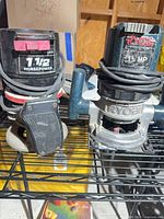 Craftsman and Ryobi routers on metal shelf