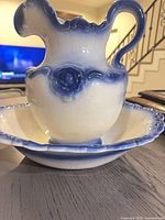 Pitcher inside wash basin, side view showing blue gradient and scalloped edges