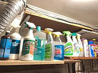 Left side view showing hydrogen peroxide, Zep cleaner, Mean Green degreaser, and additional spray bottles