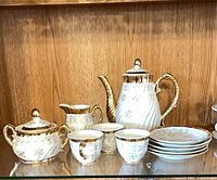 Full view of tea service showing teapot, sugar bowl, creamer, cups, saucers