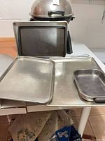 Assortment of metal baking sheets and pans on table