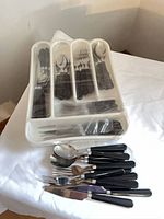 Cutlery pieces laid out with organizer tray showing variety of utensils